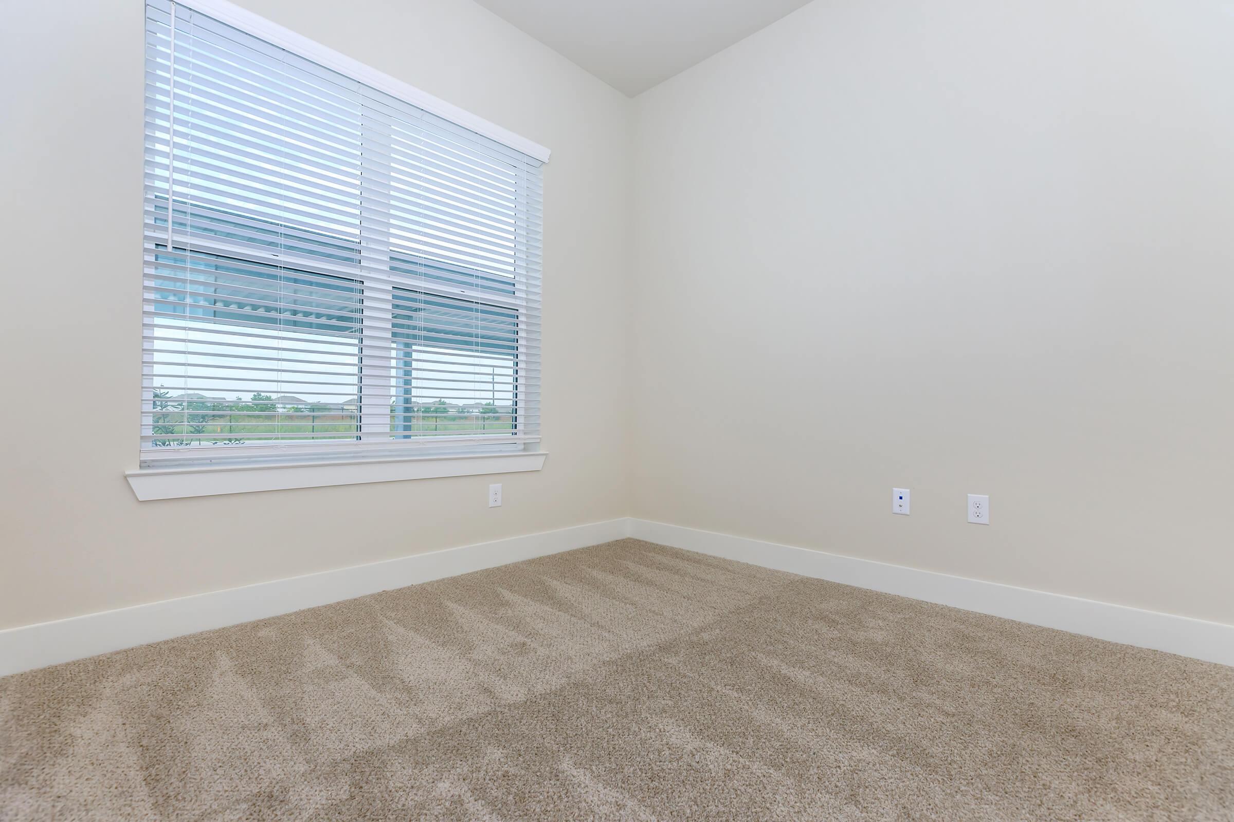 bedroom at ivy point kingwood senior living apartments in kingwood tx featuring carpeted flooring and windows with blinds