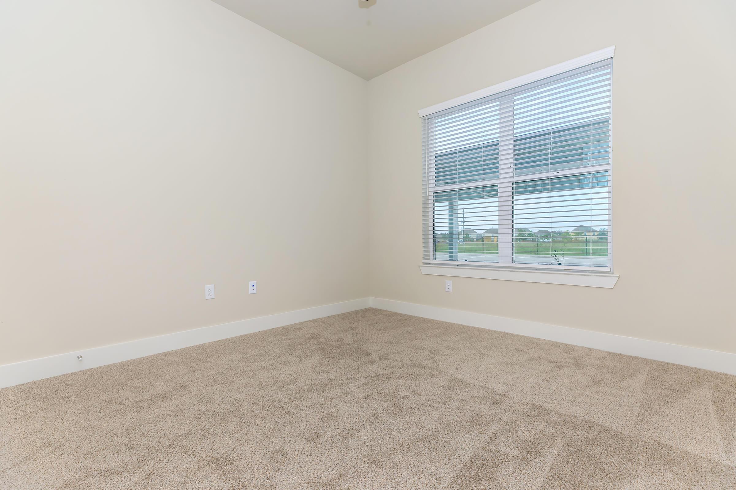 bedroom at ivy point kingwood senior living apartments in kingwood tx featuring carpeted flooring and windows with blinds