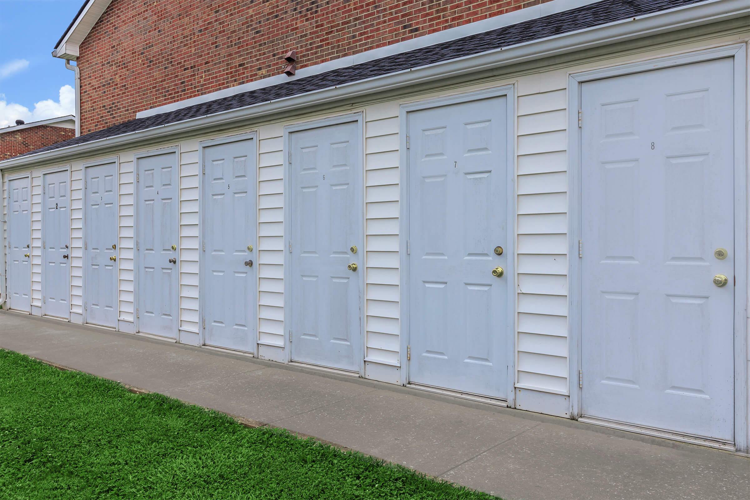 a large brick building with grass in front of a door