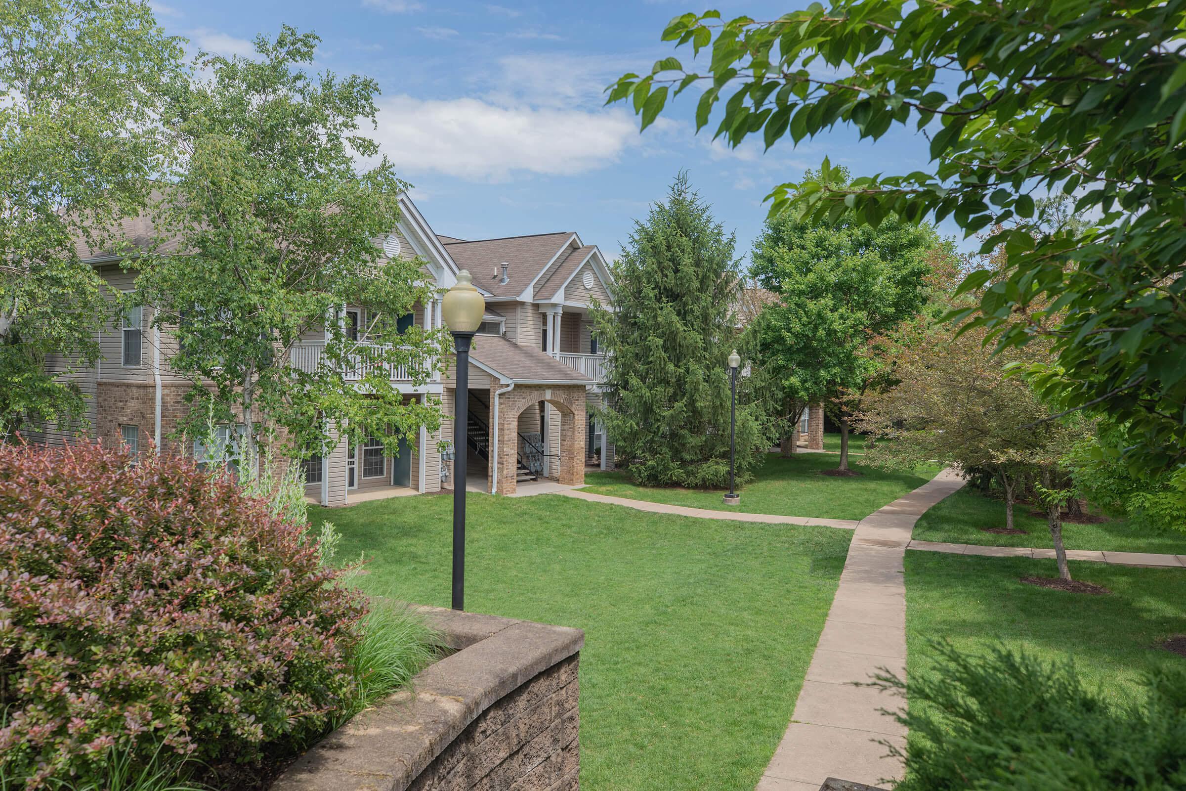 a house with bushes in front of a brick building