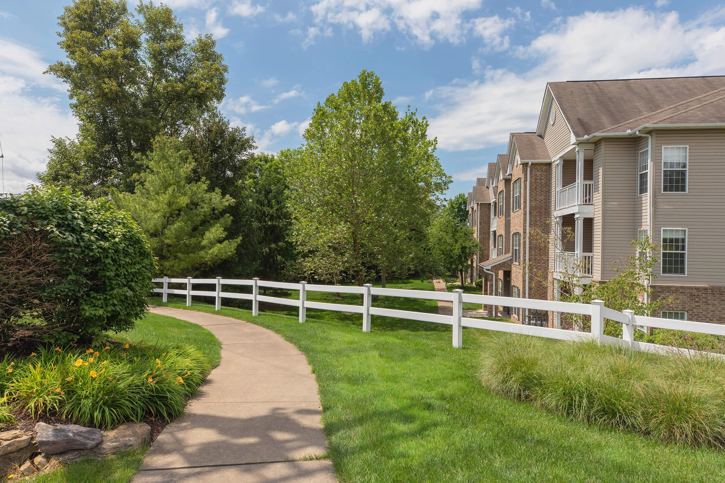 a path with grass in front of a house