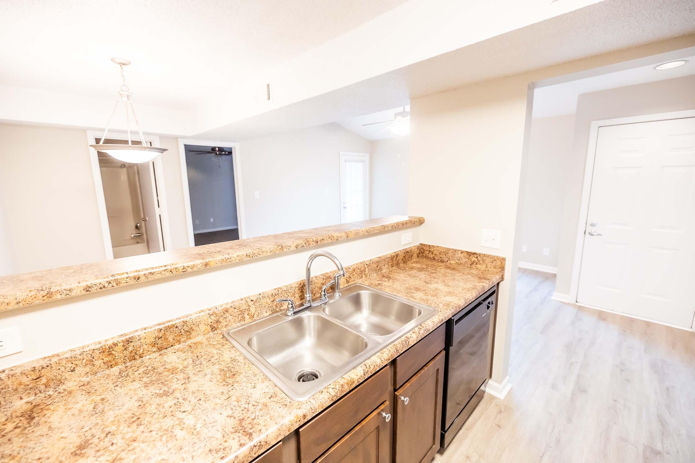 a kitchen with a sink and a mirror