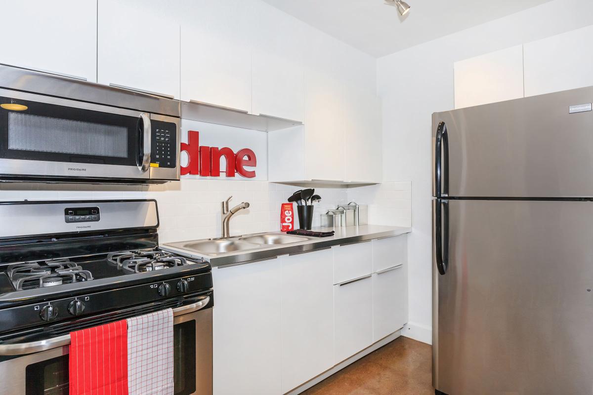 a white stove top oven sitting inside of a kitchen with stainless steel appliances
