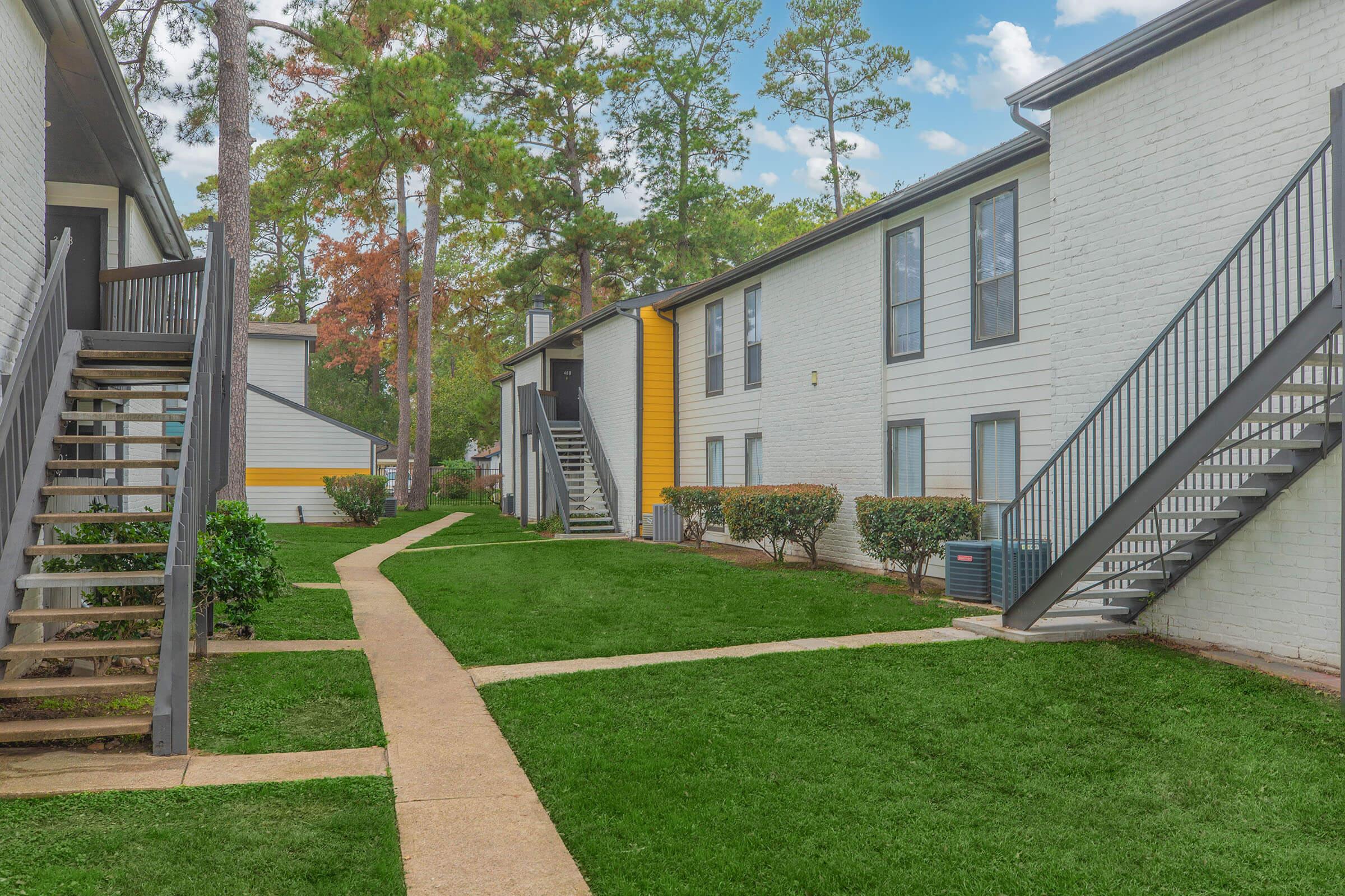 a house with a lawn in front of a brick building