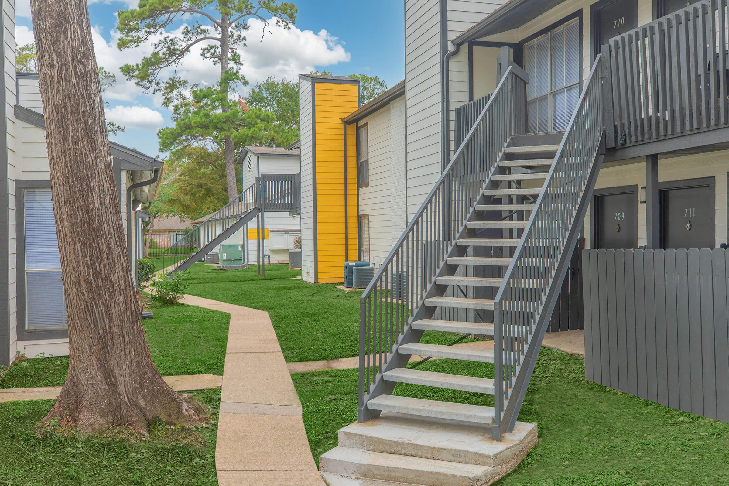 a path with trees on the side of a building