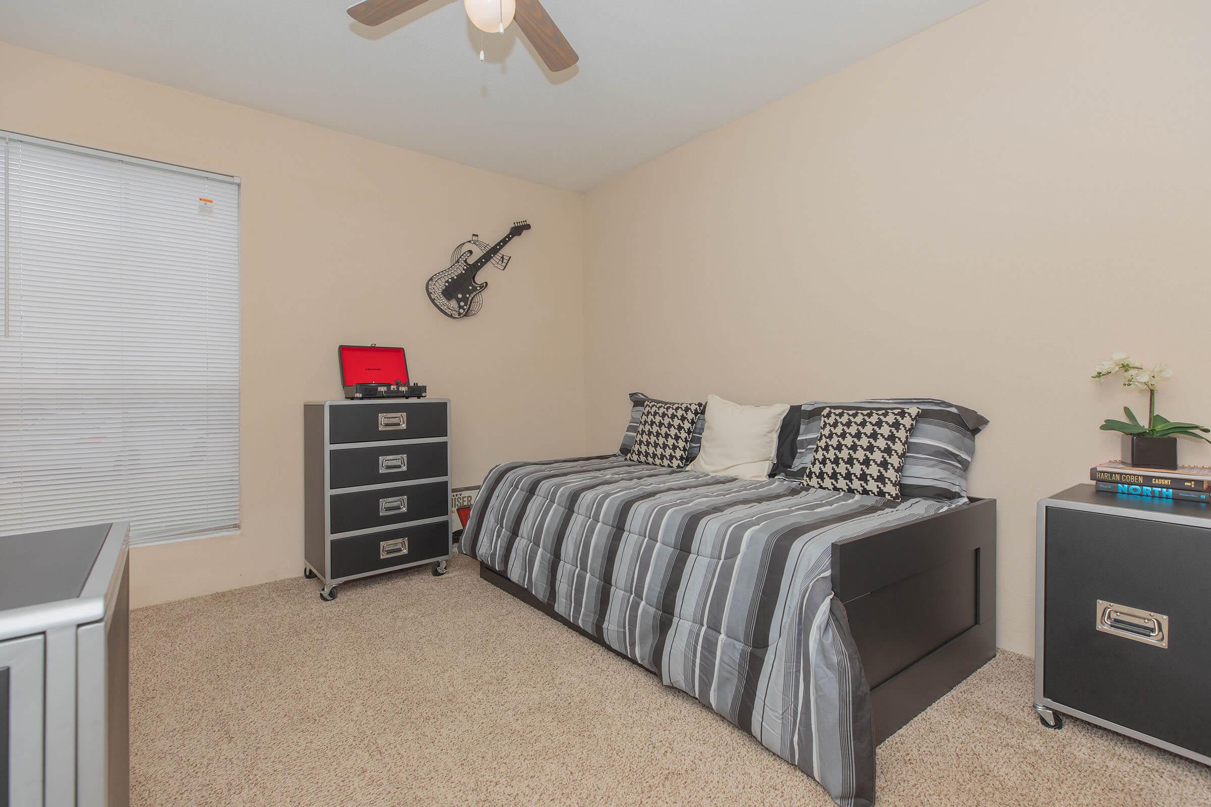 a bedroom with a bed and desk in a small room