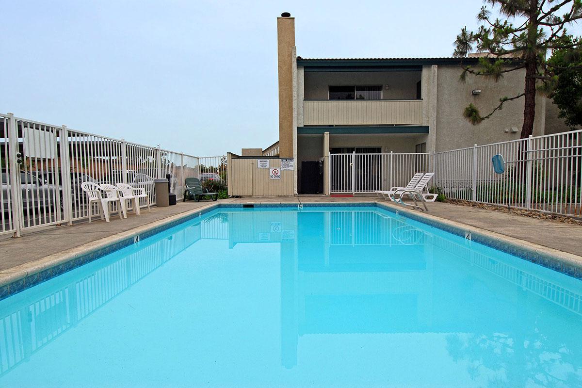 Community pool with white lawn chairs