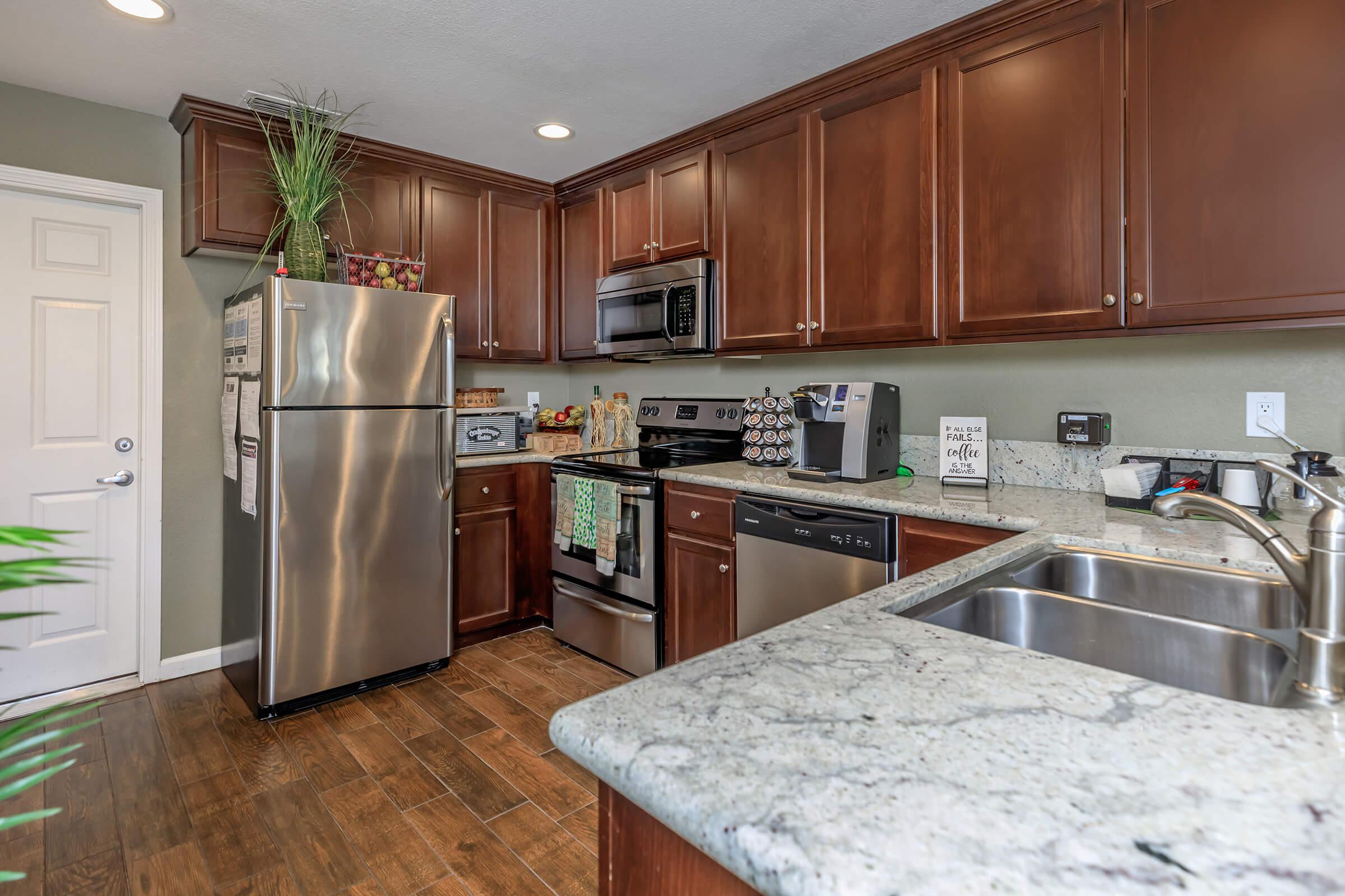 a modern kitchen with stainless steel appliances and wooden cabinets