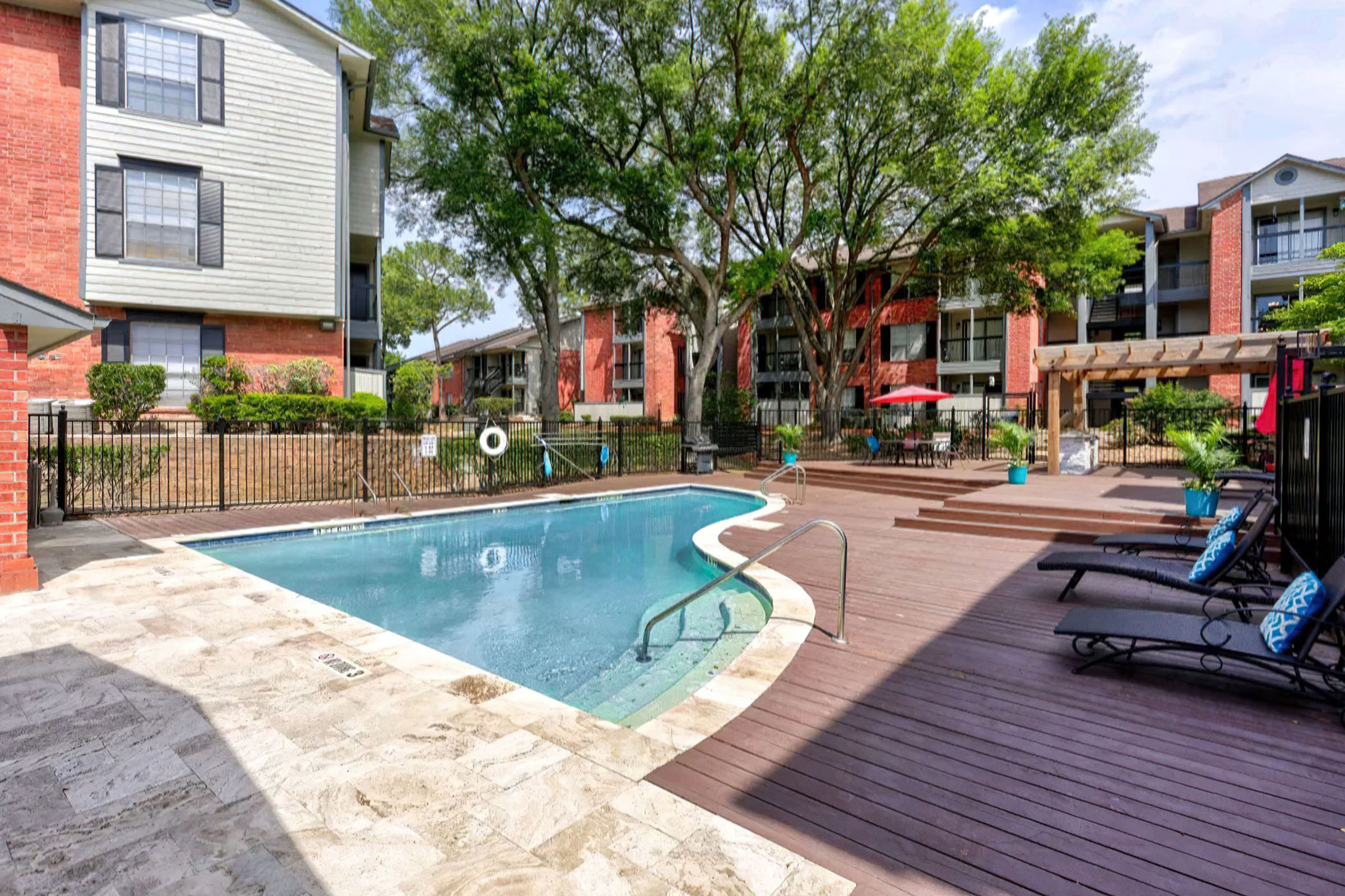 a house with a pool in front of a brick building