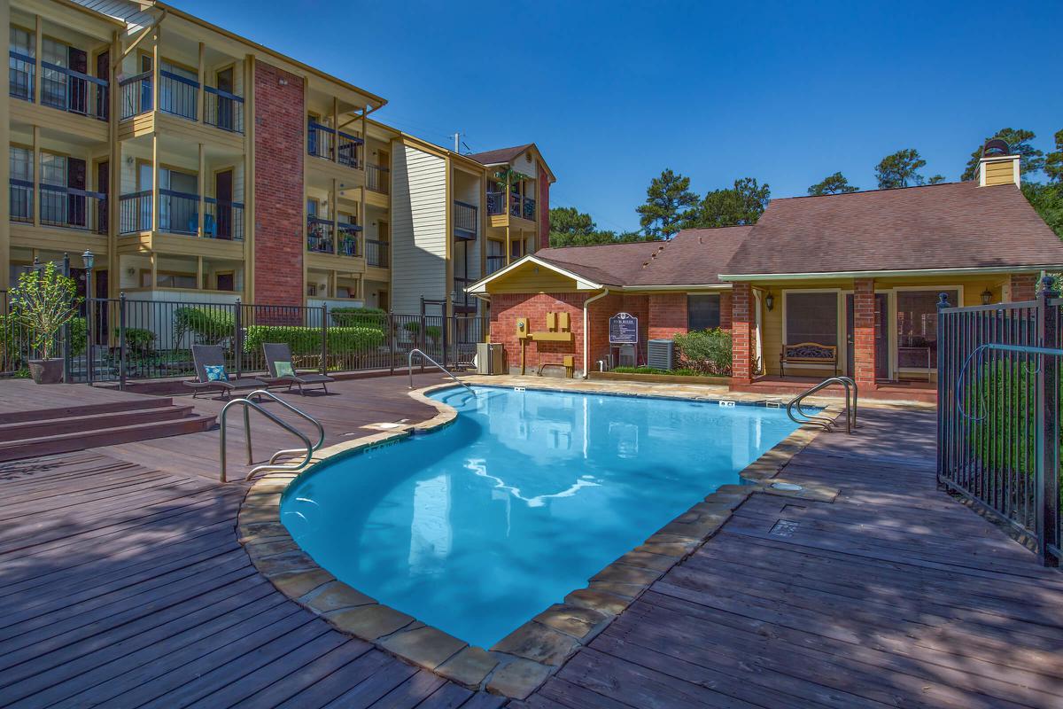 a house with a pool in front of a brick building