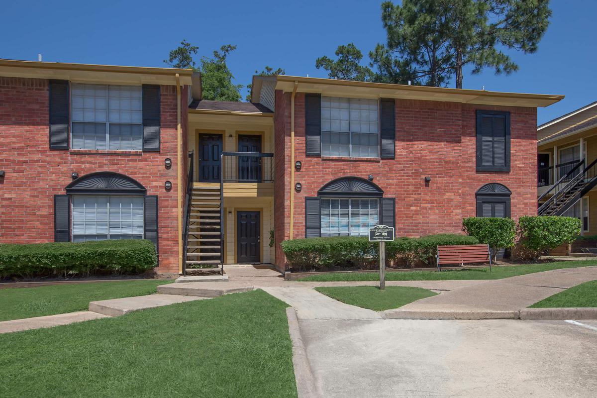 a large brick building with grass in front of a house