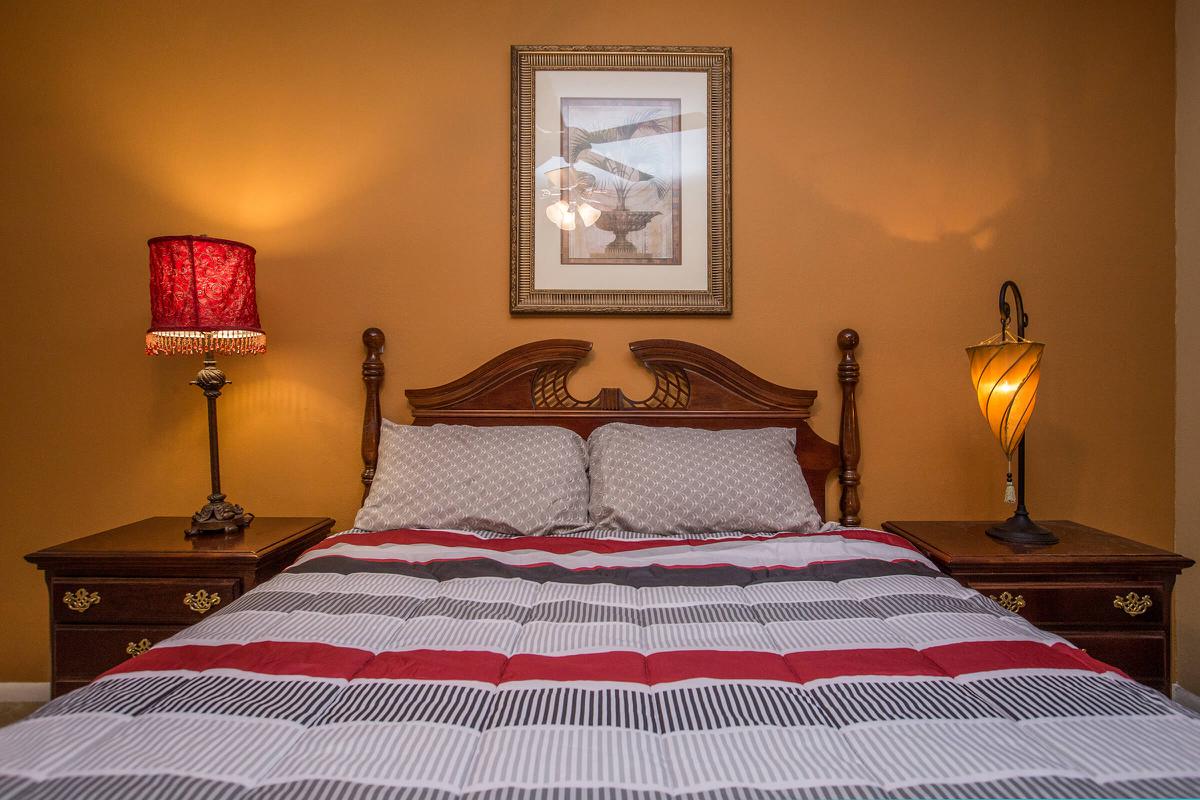 a double bed with a lamp on a table