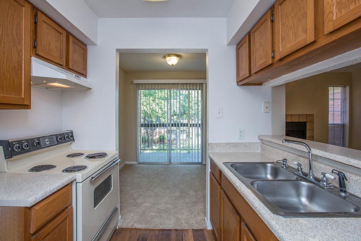 a kitchen with a stove a sink and a window