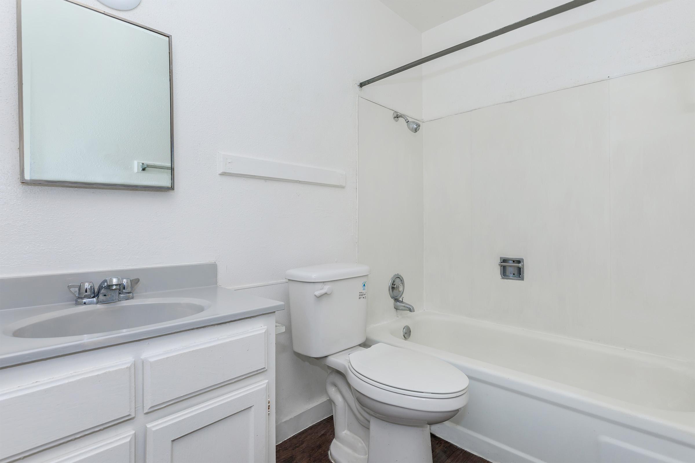 a white sink sitting under a mirror