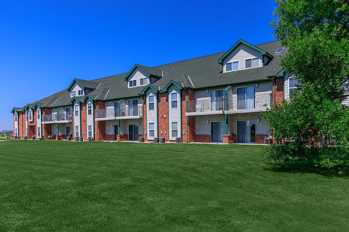 a large green field in front of a house