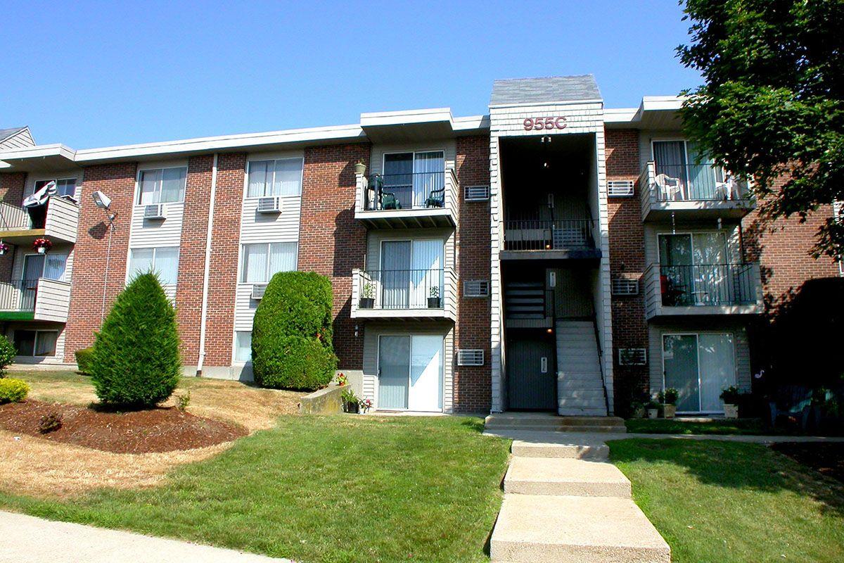 a house with a lawn in front of a brick building