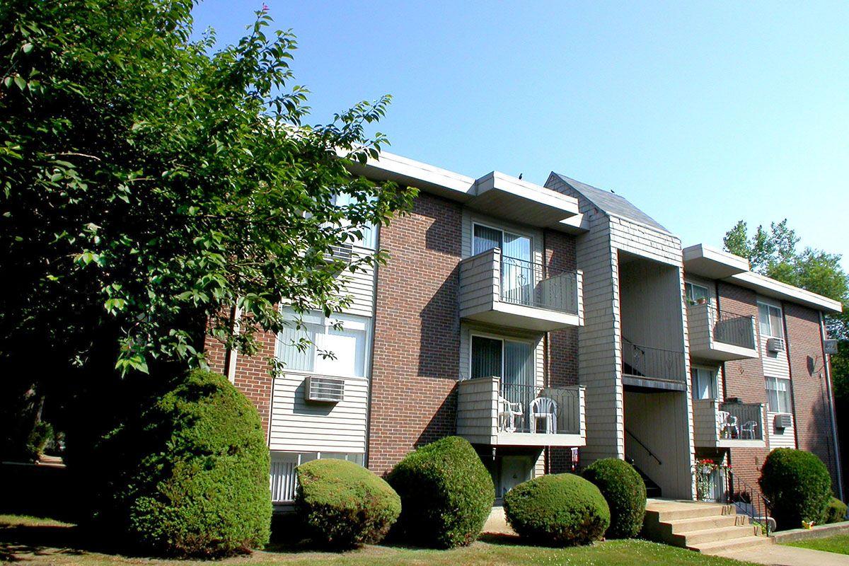 a house with bushes in front of a brick building