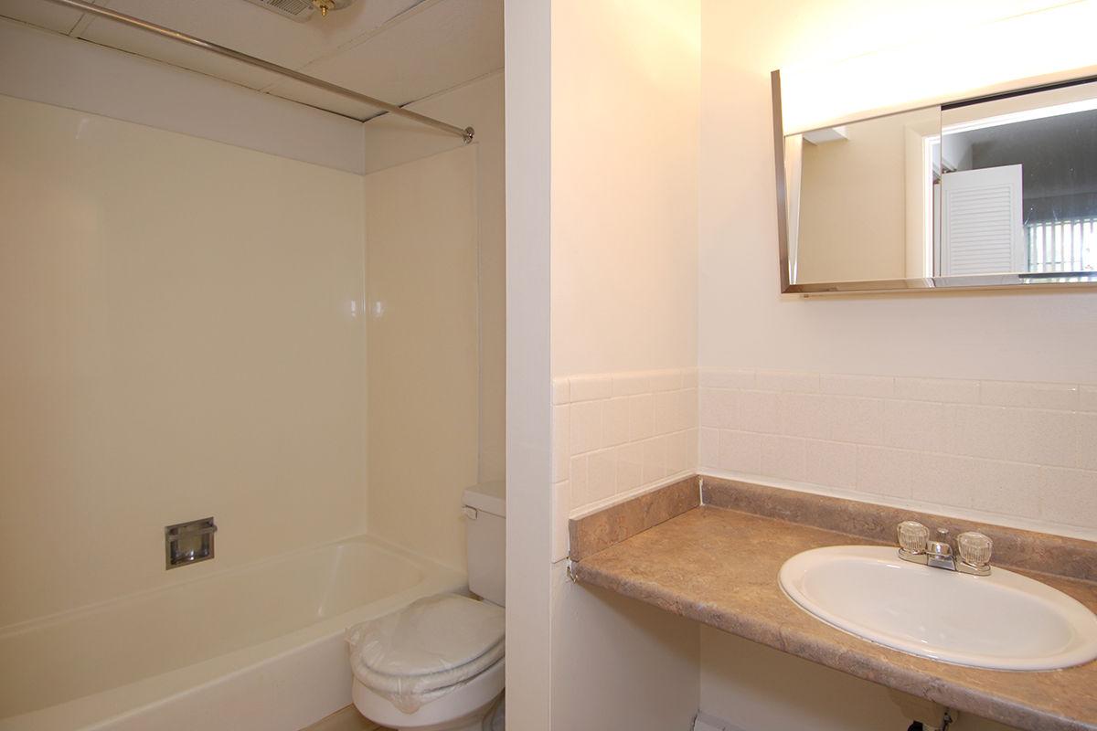 a white sink sitting under a mirror