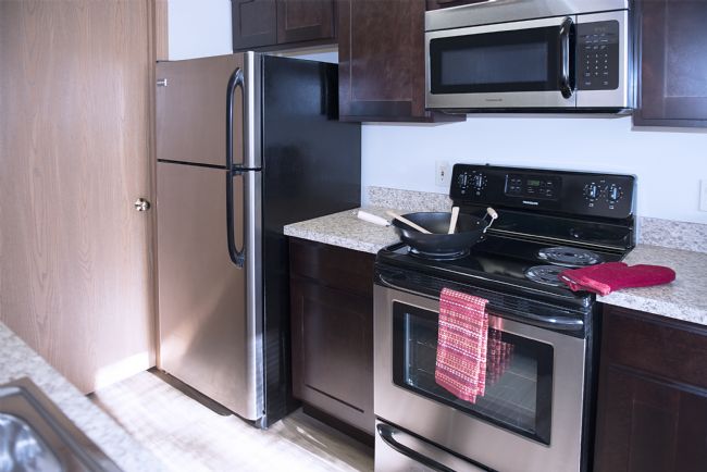 a stove top oven sitting inside of a kitchen with stainless steel appliances