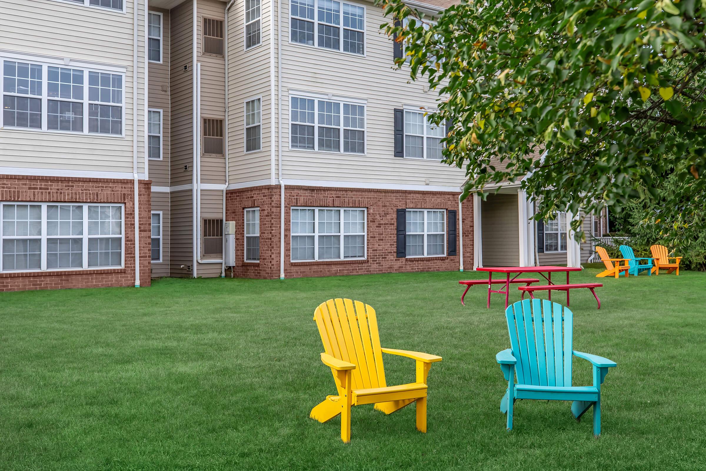 a couple of lawn chairs sitting on a bench in front of a building