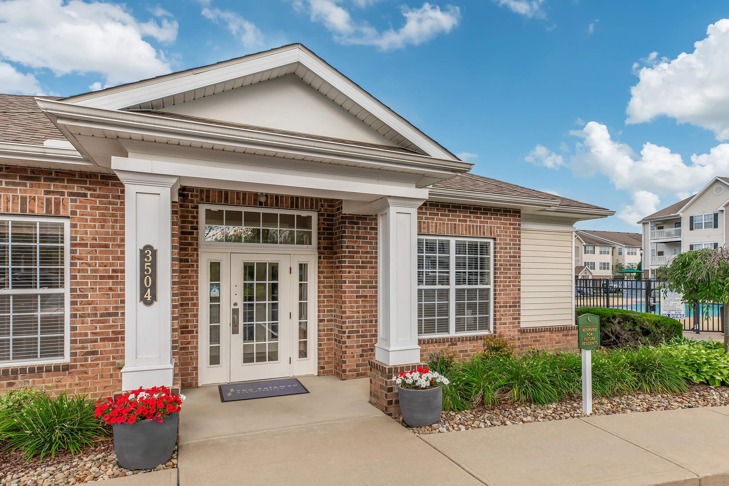 a house in front of a brick building