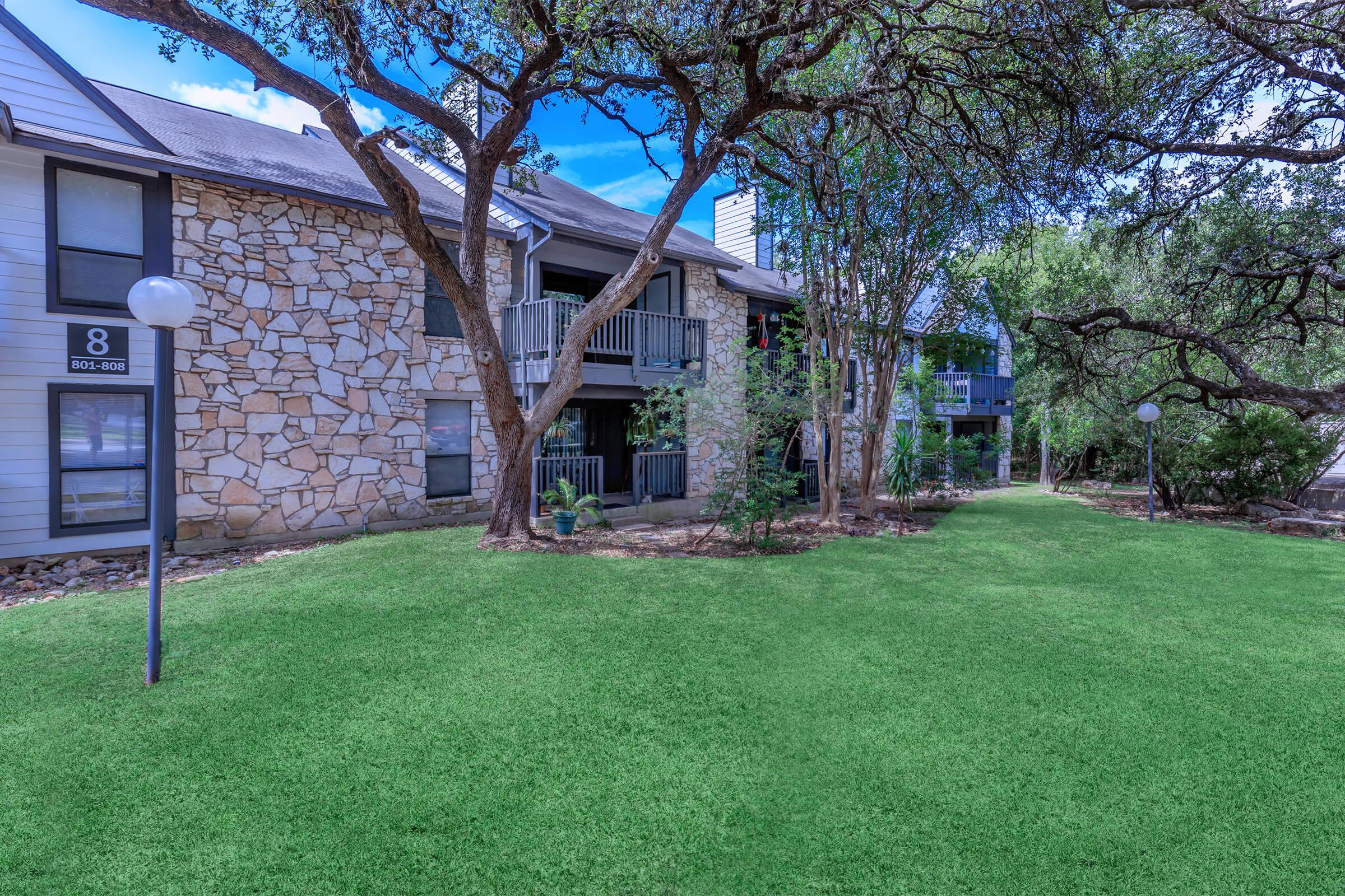 a house with a lawn in front of a brick building