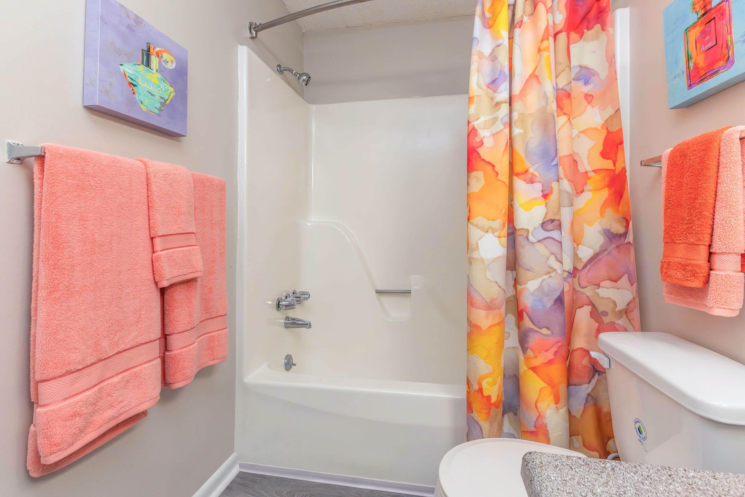 a pink tub and sink and shower curtain