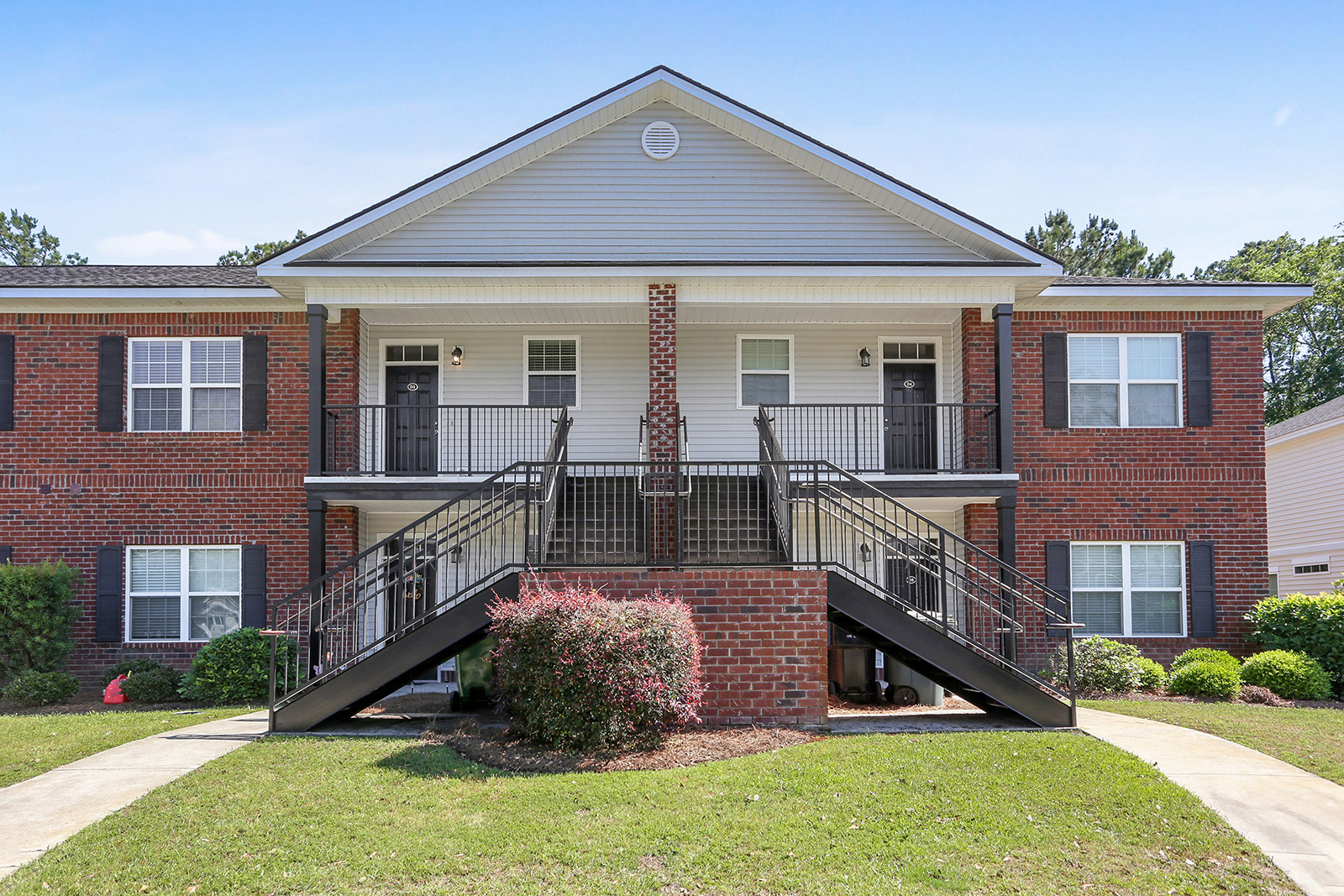 a large brick building with grass in front of a house