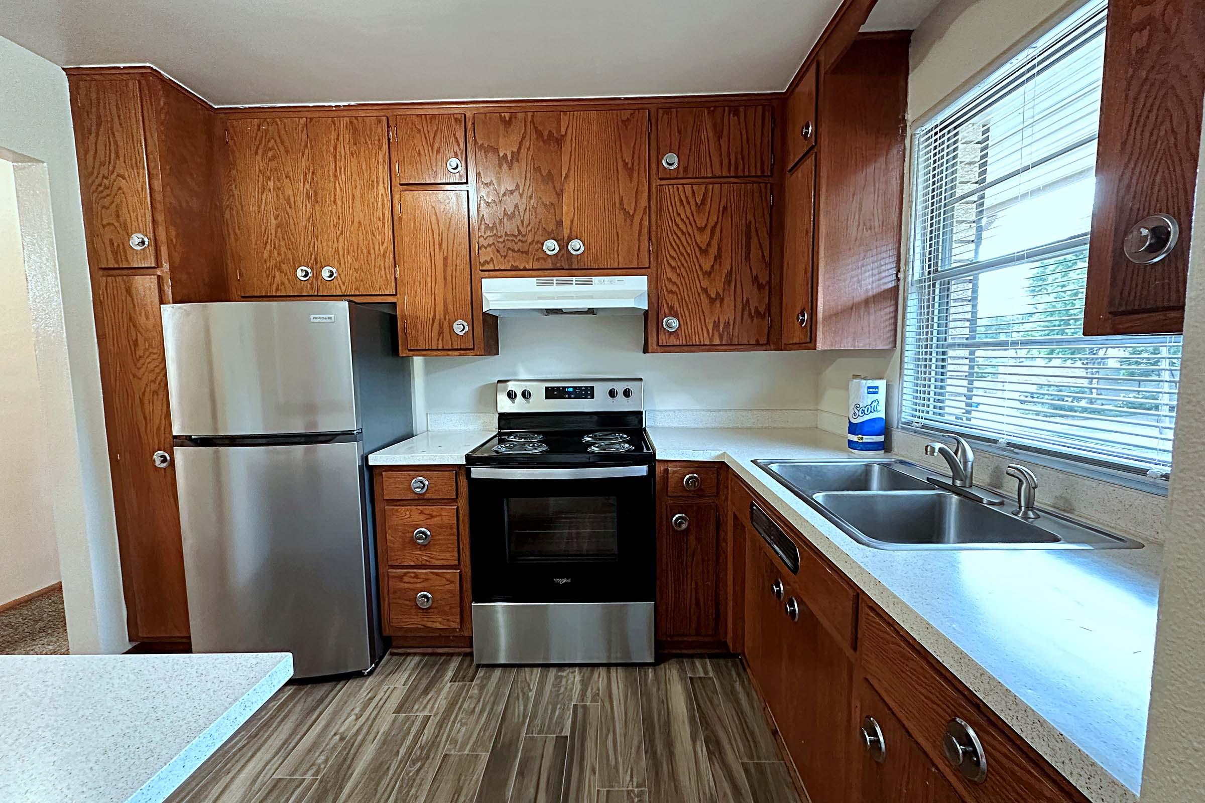 a modern kitchen with stainless steel appliances and wooden cabinets