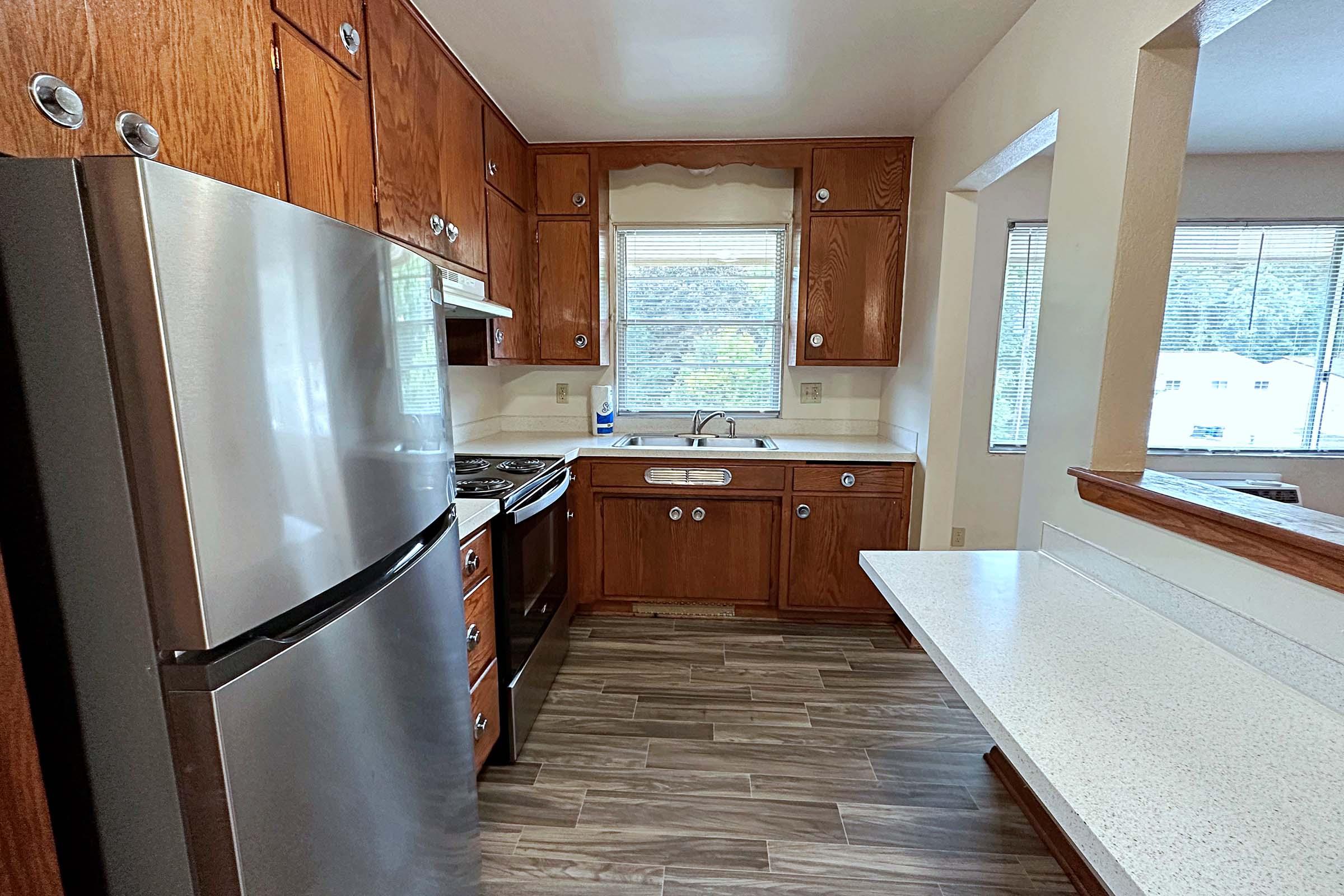 a kitchen with wooden cabinets and a window