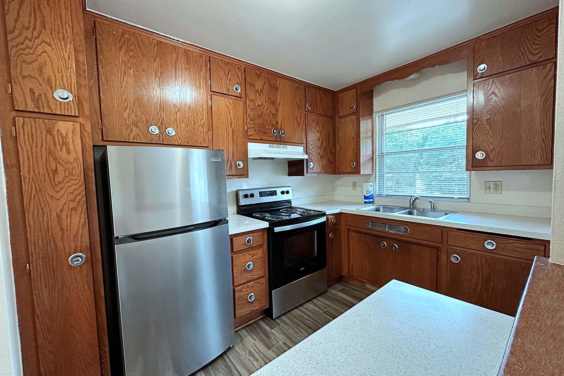 a modern kitchen with stainless steel appliances and wooden cabinets