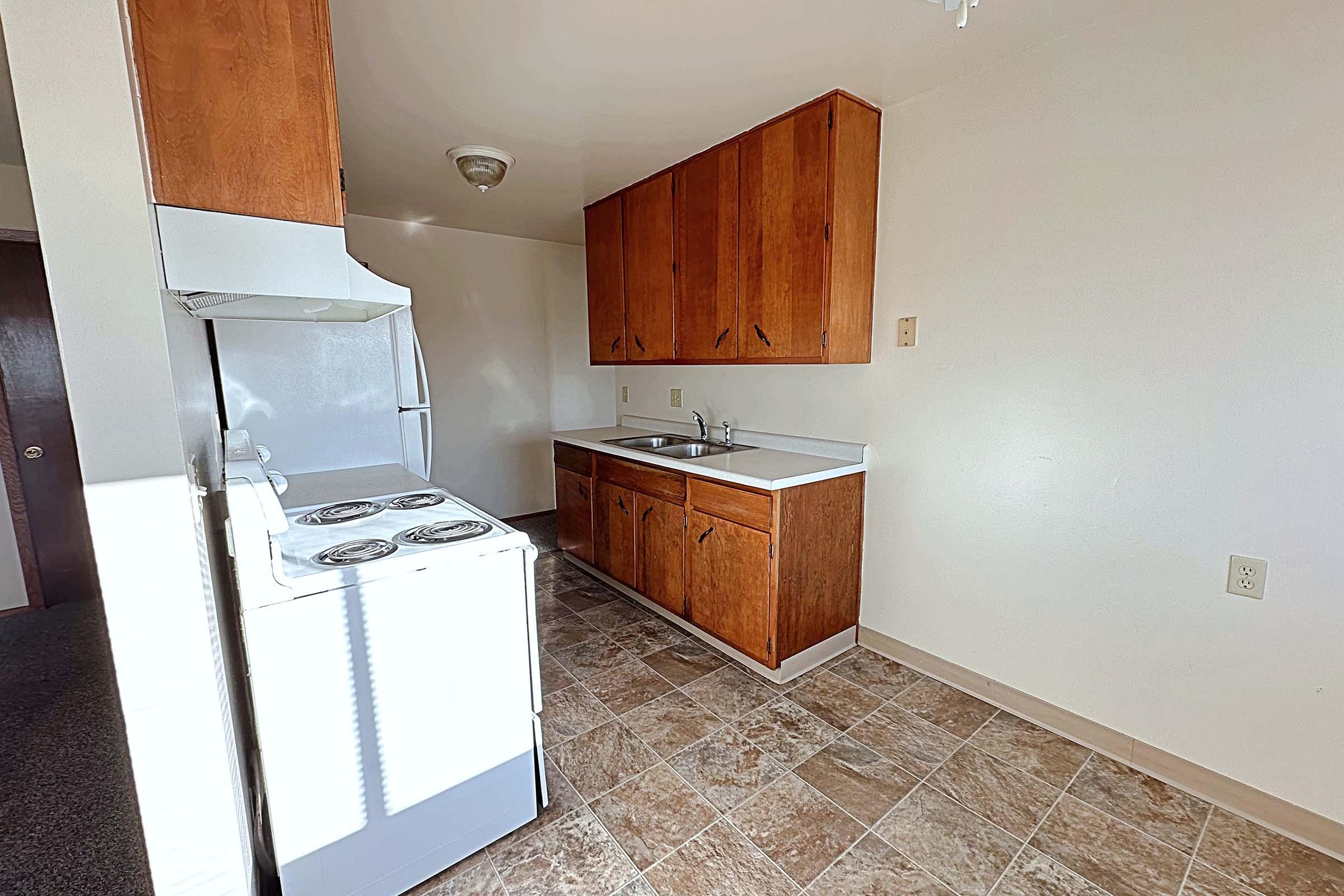 a kitchen with wooden cabinets and a refrigerator