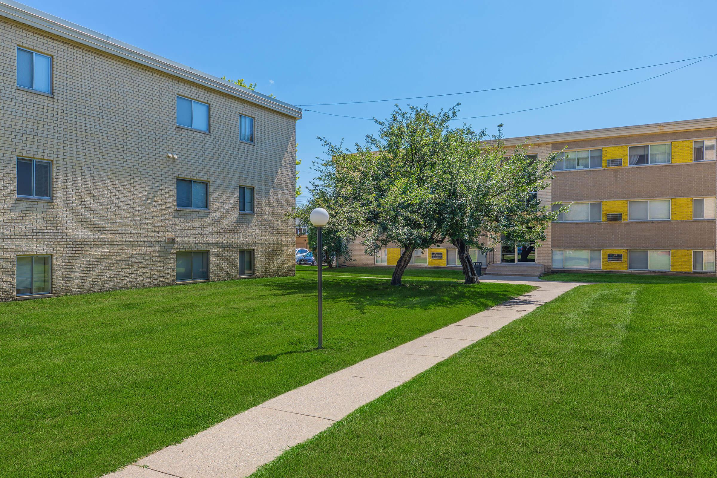 a large brick building with green grass