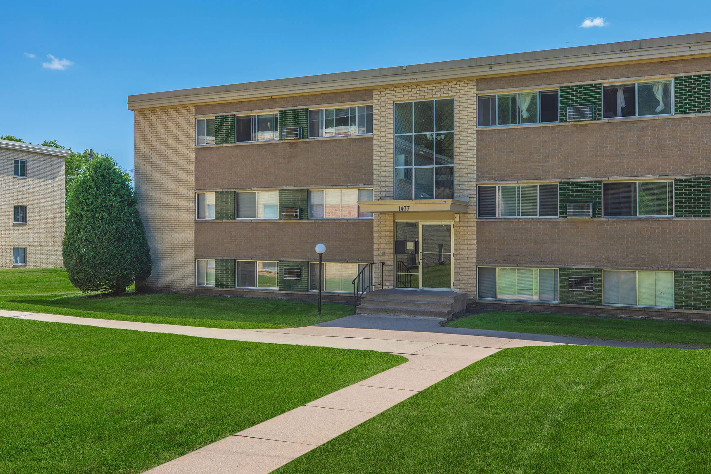 a large lawn in front of a brick building