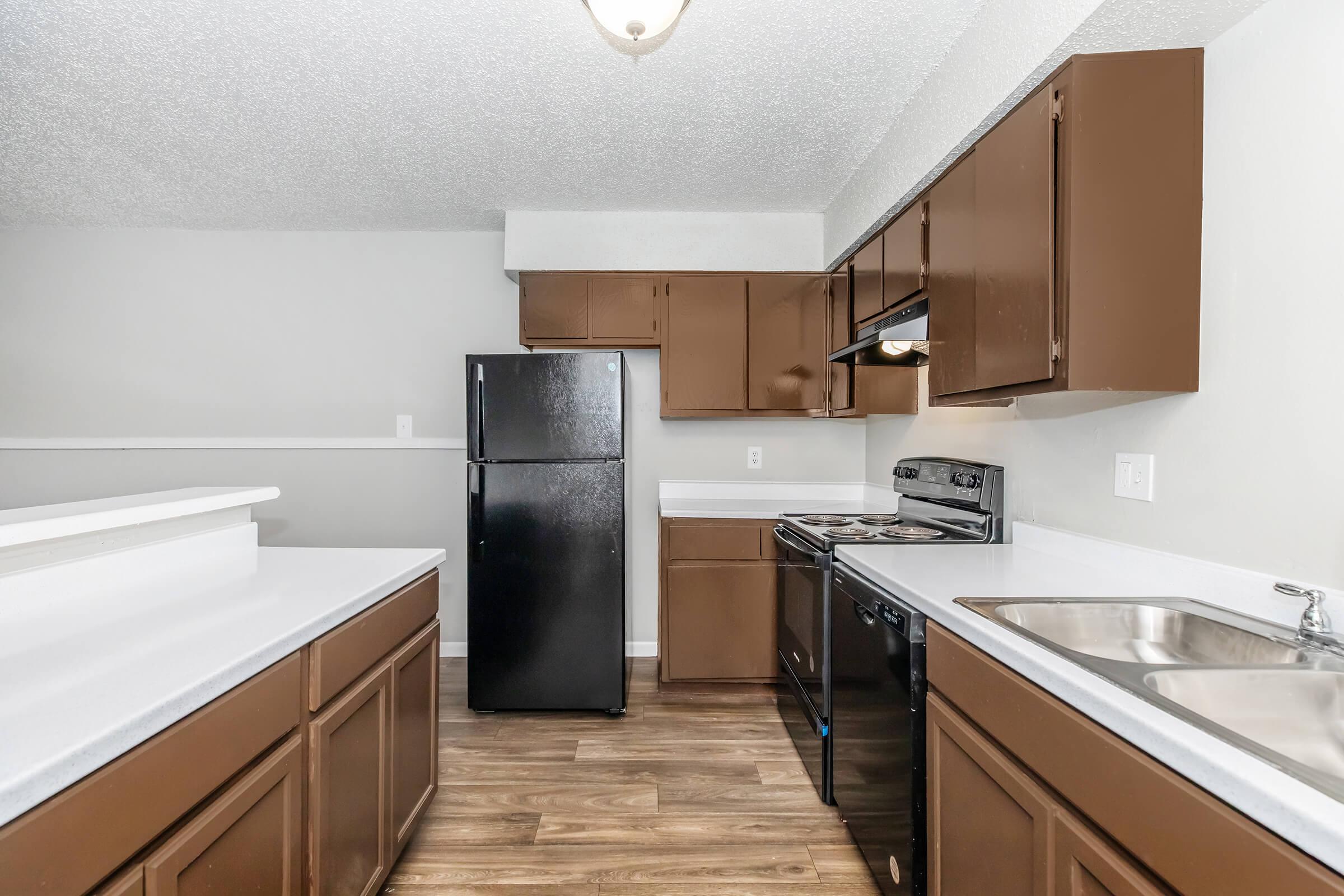 a large kitchen with stainless steel appliances and wooden cabinets