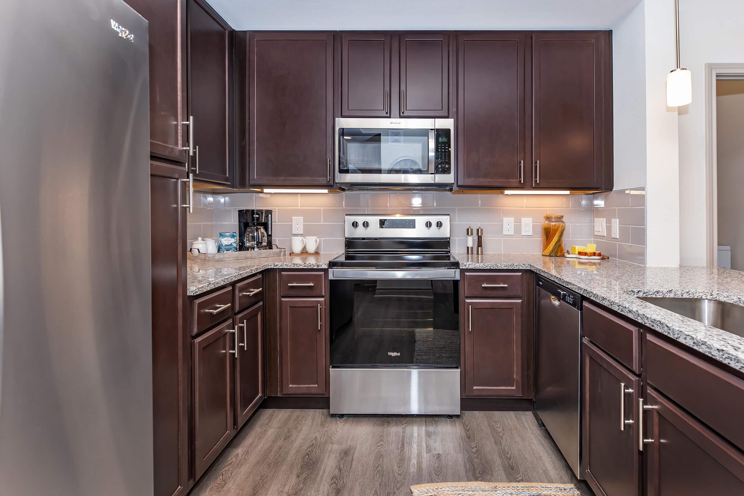 a modern kitchen with stainless steel appliances and wooden cabinets