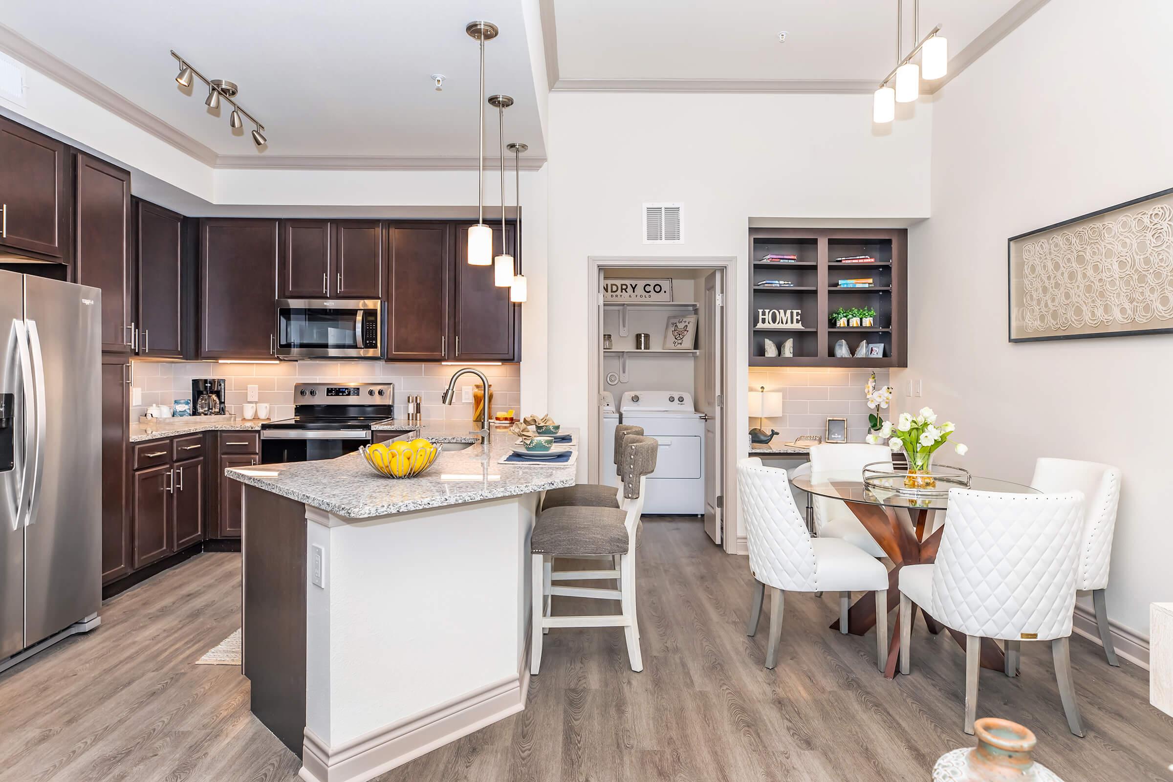 a living room filled with furniture and a table in a kitchen