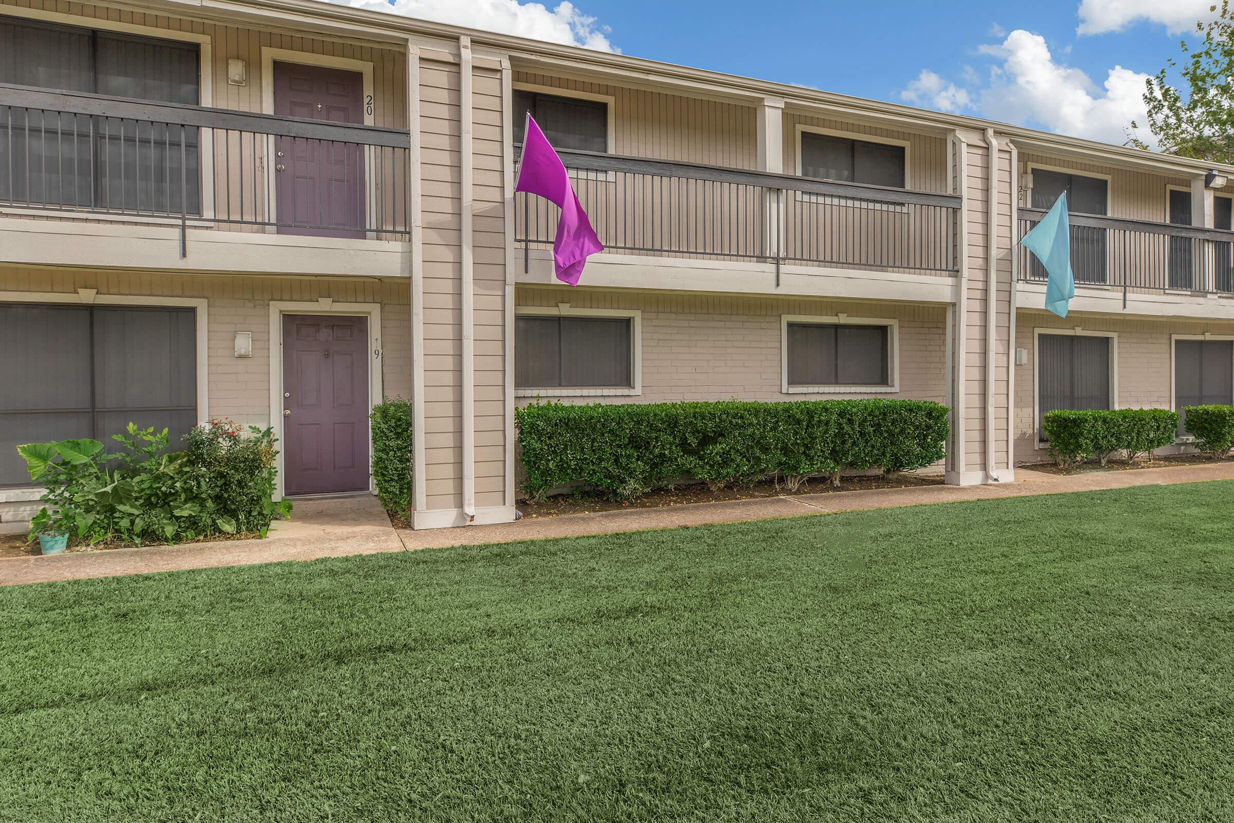 a girl flying a kite in front of a building