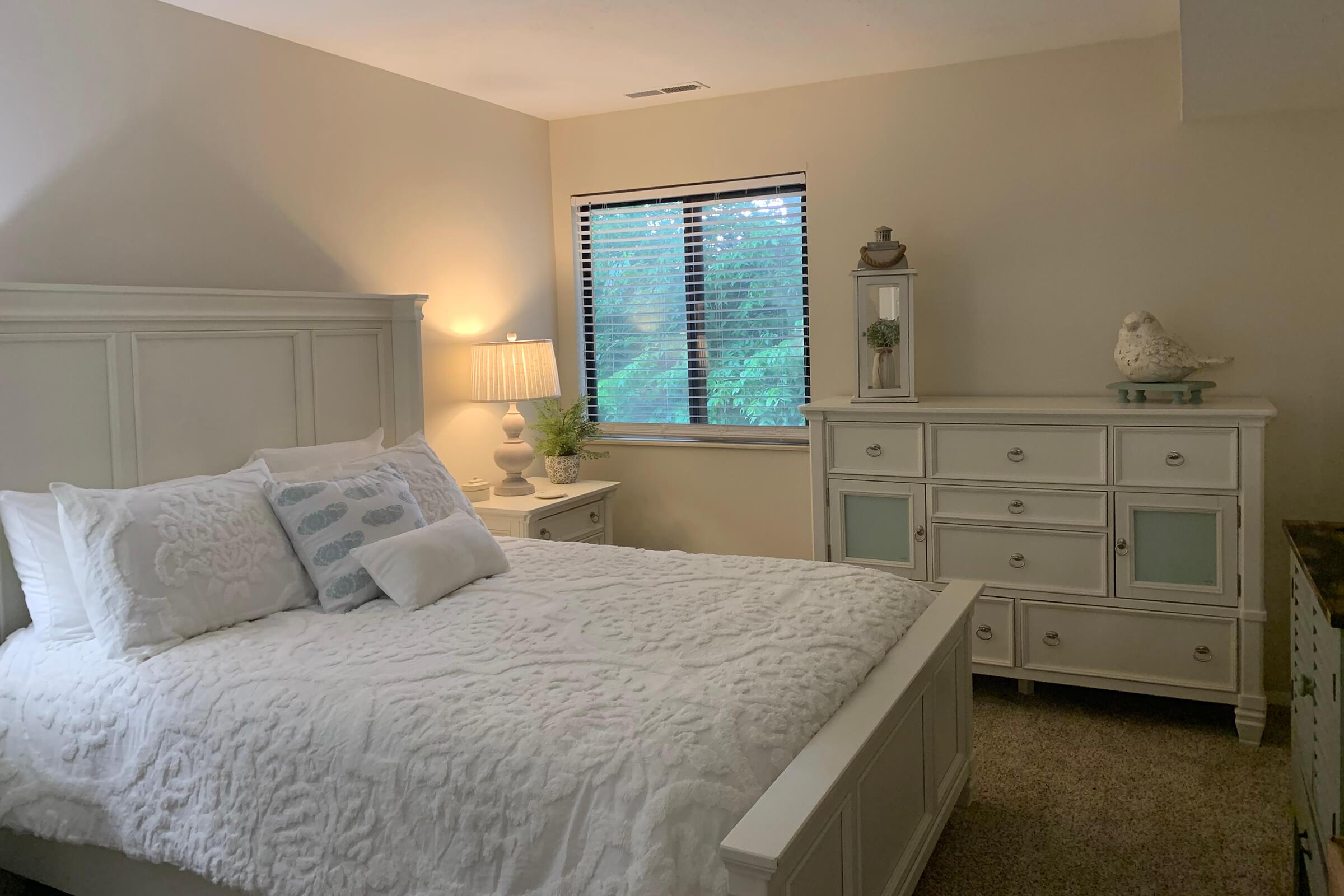 a bedroom with a bed and desk in a small room