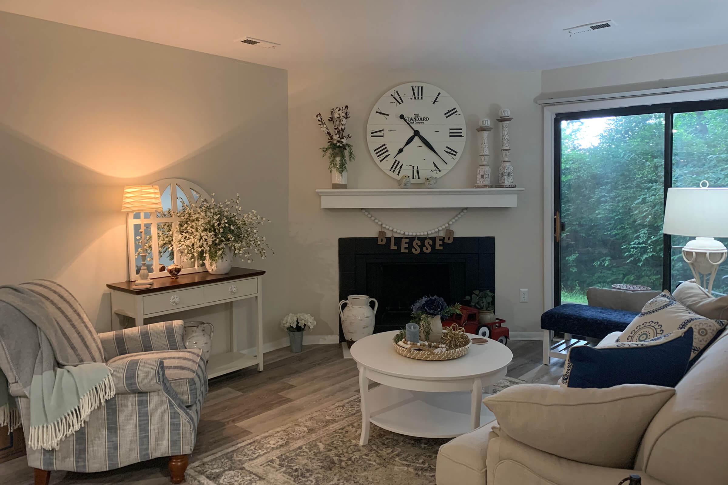 a living room filled with furniture and a clock