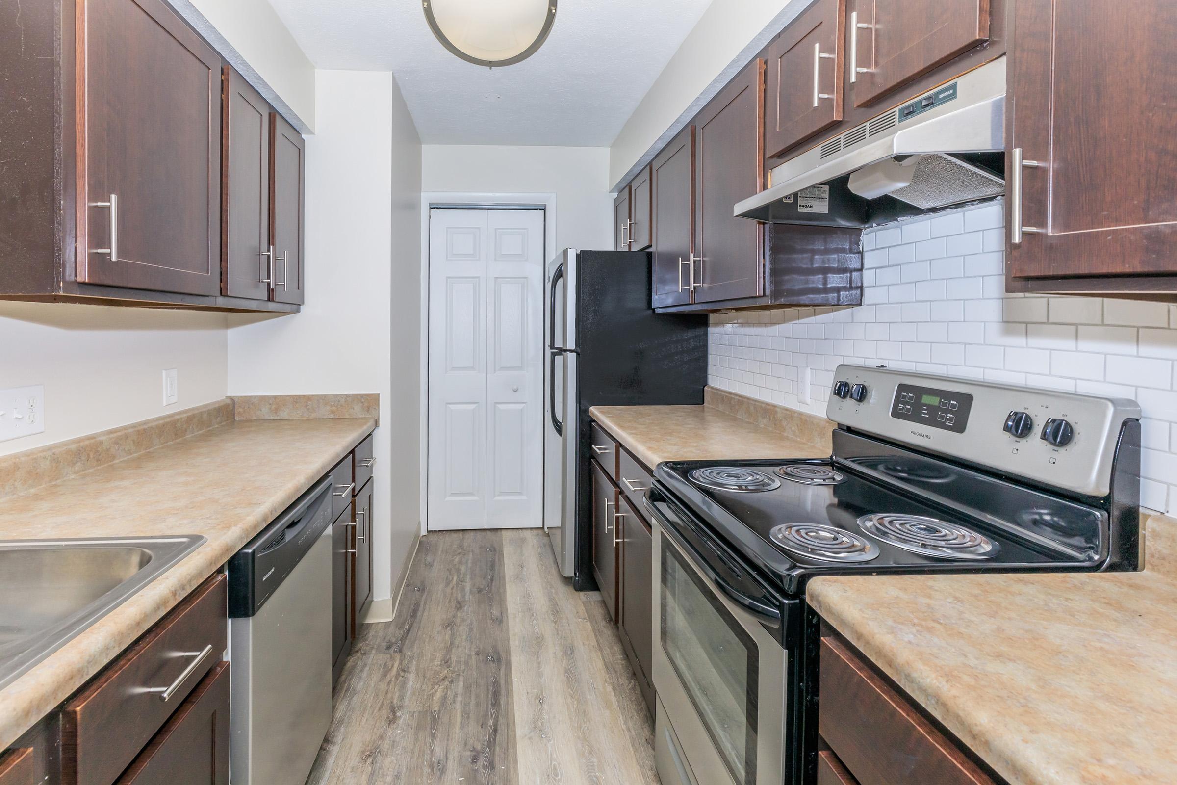 a modern kitchen with stainless steel appliances and wooden cabinets