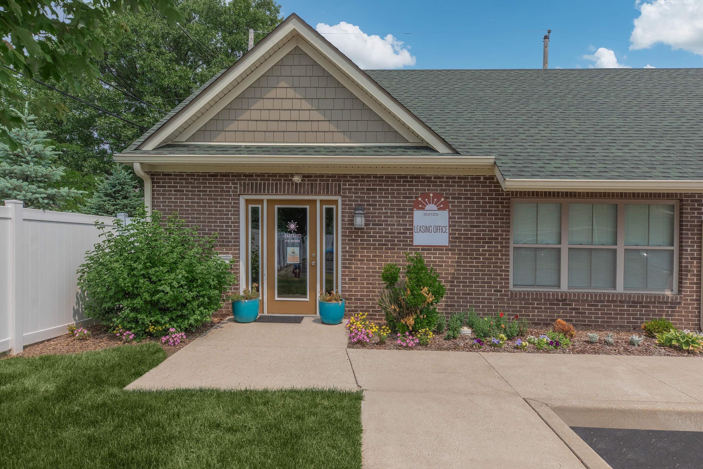 a large brick building with grass in front of a house