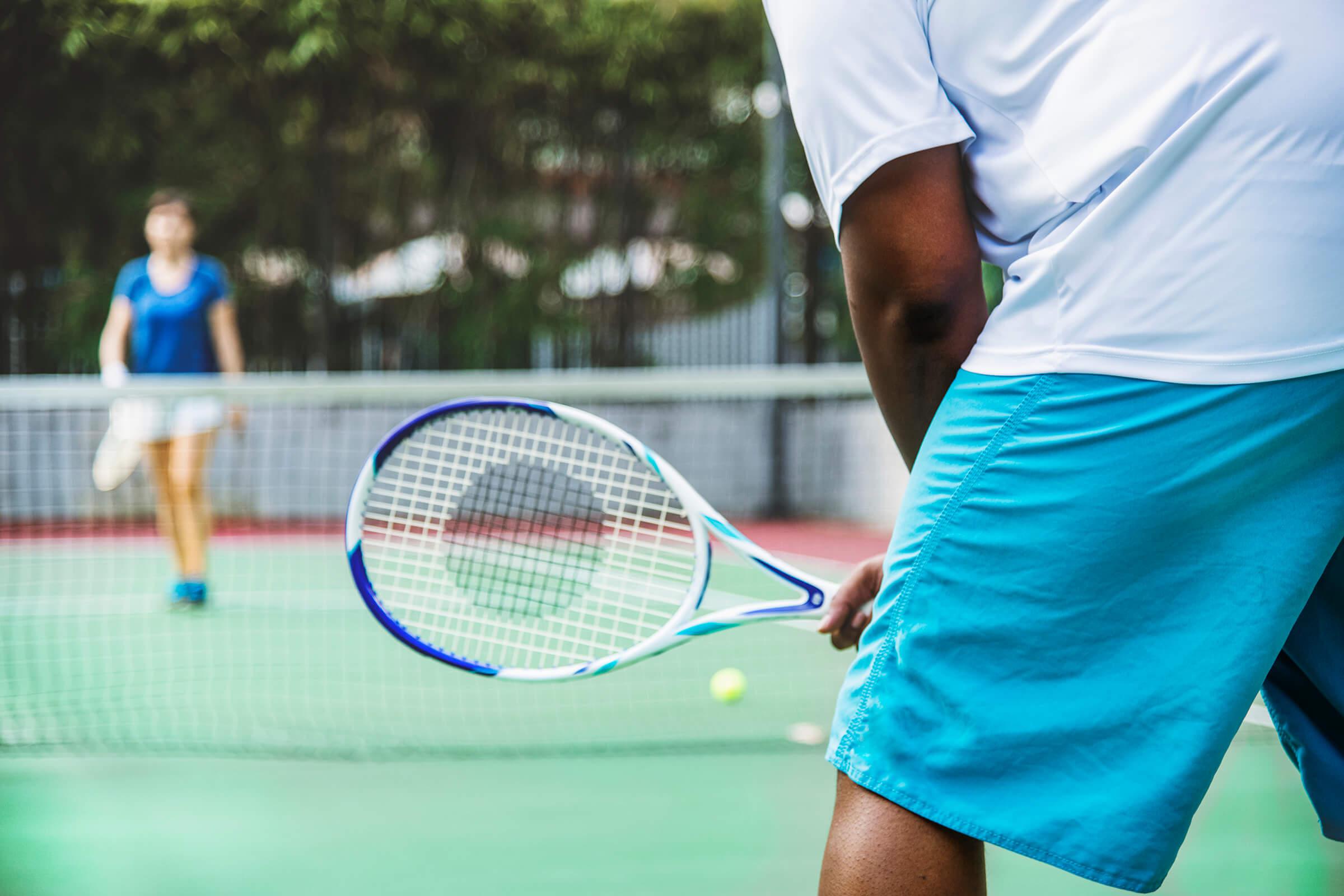 a person holding a racket on a court