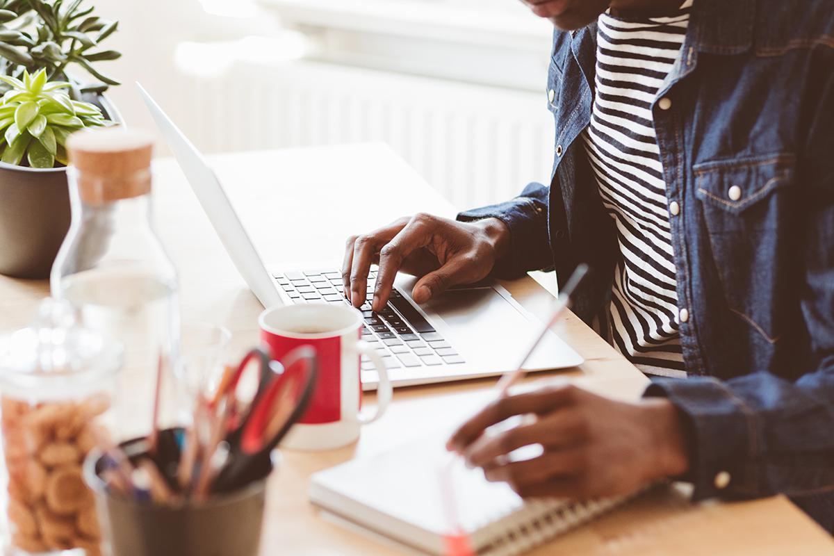 Young man working on laptop and taking notes iStock-667018224.jpg