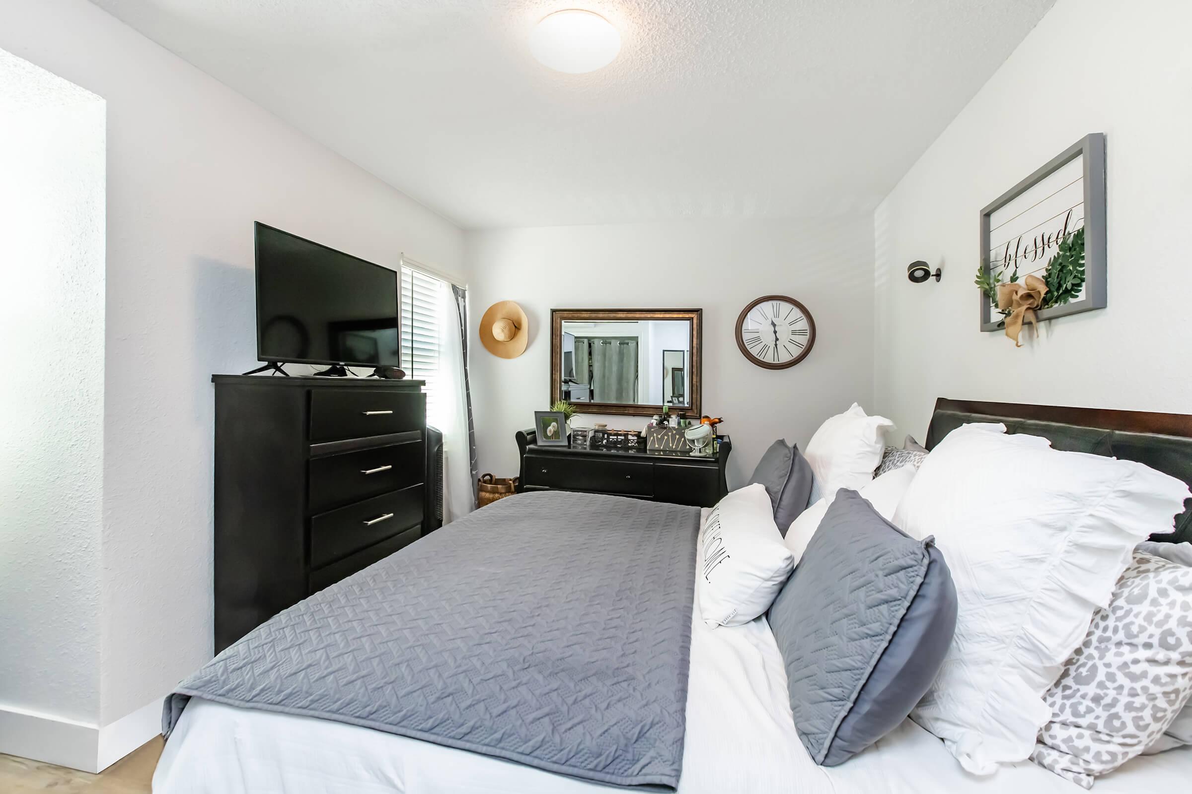 a bedroom with a bed and desk in a room