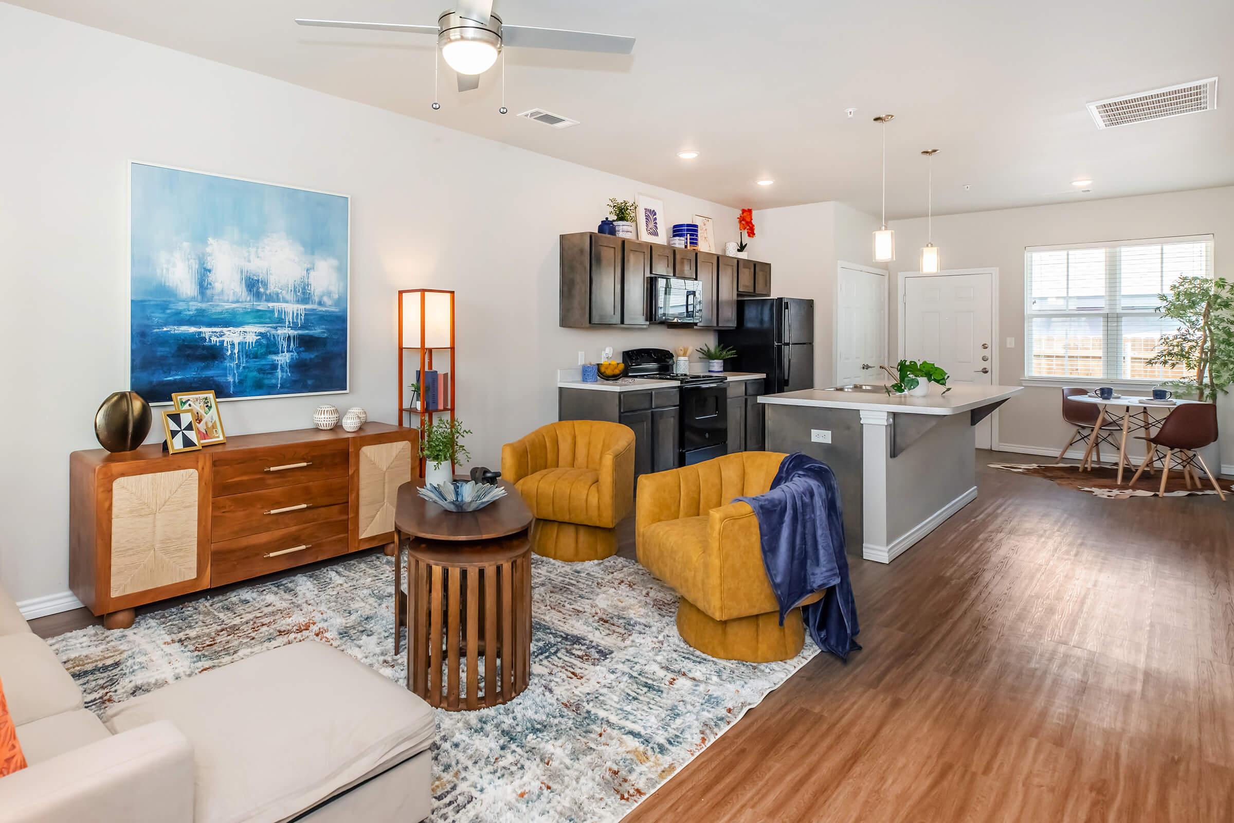 a living room filled with furniture on top of a hard wood floor