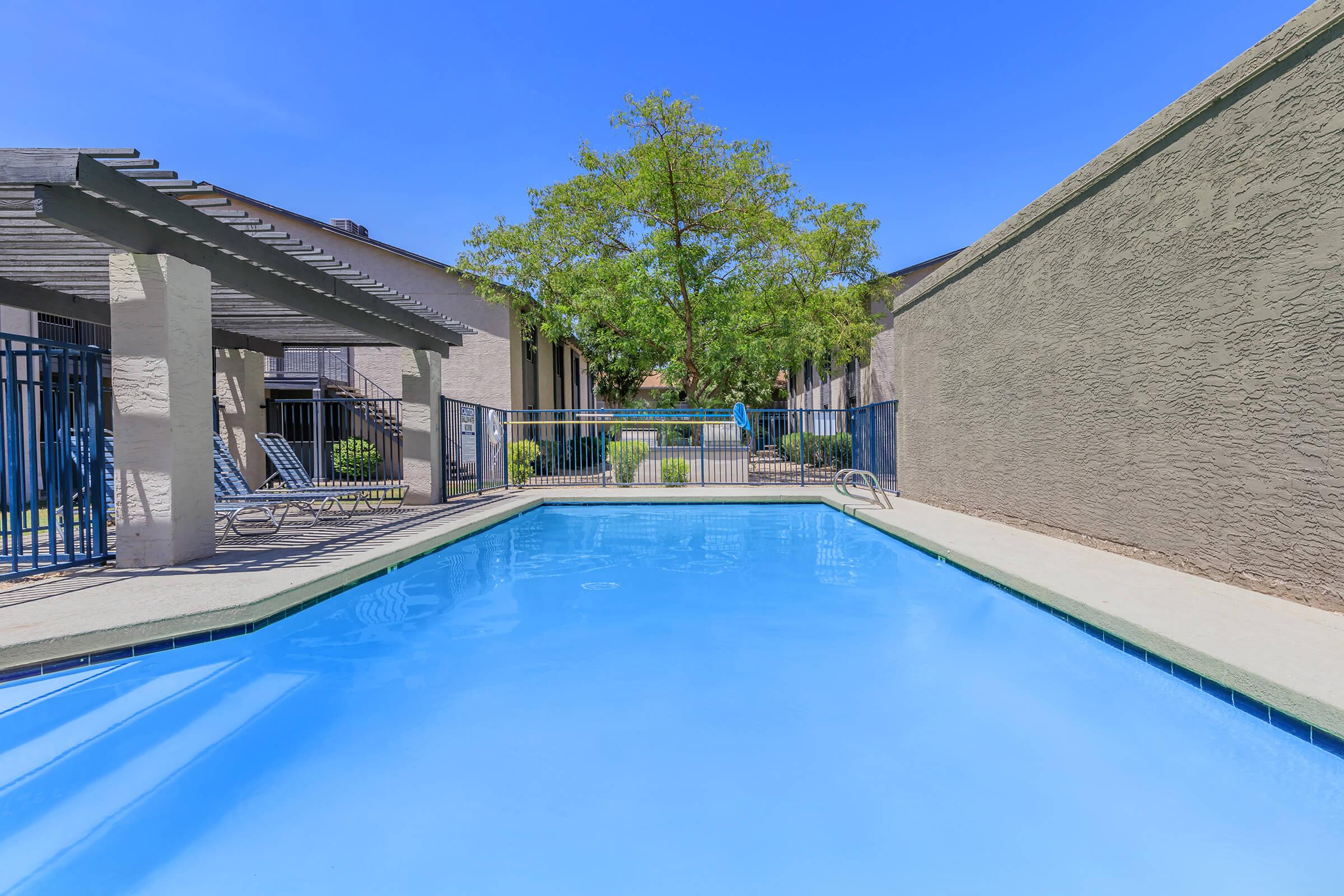 Closeup view of a large blue sparkling outdoor swimming pool at Rise on Cave Creek apartments