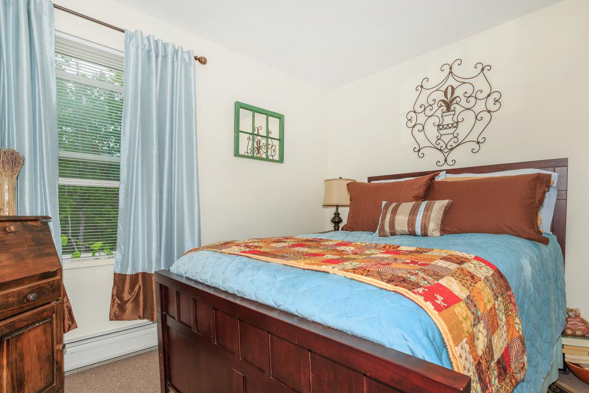 a bedroom with a neatly made bed in a room