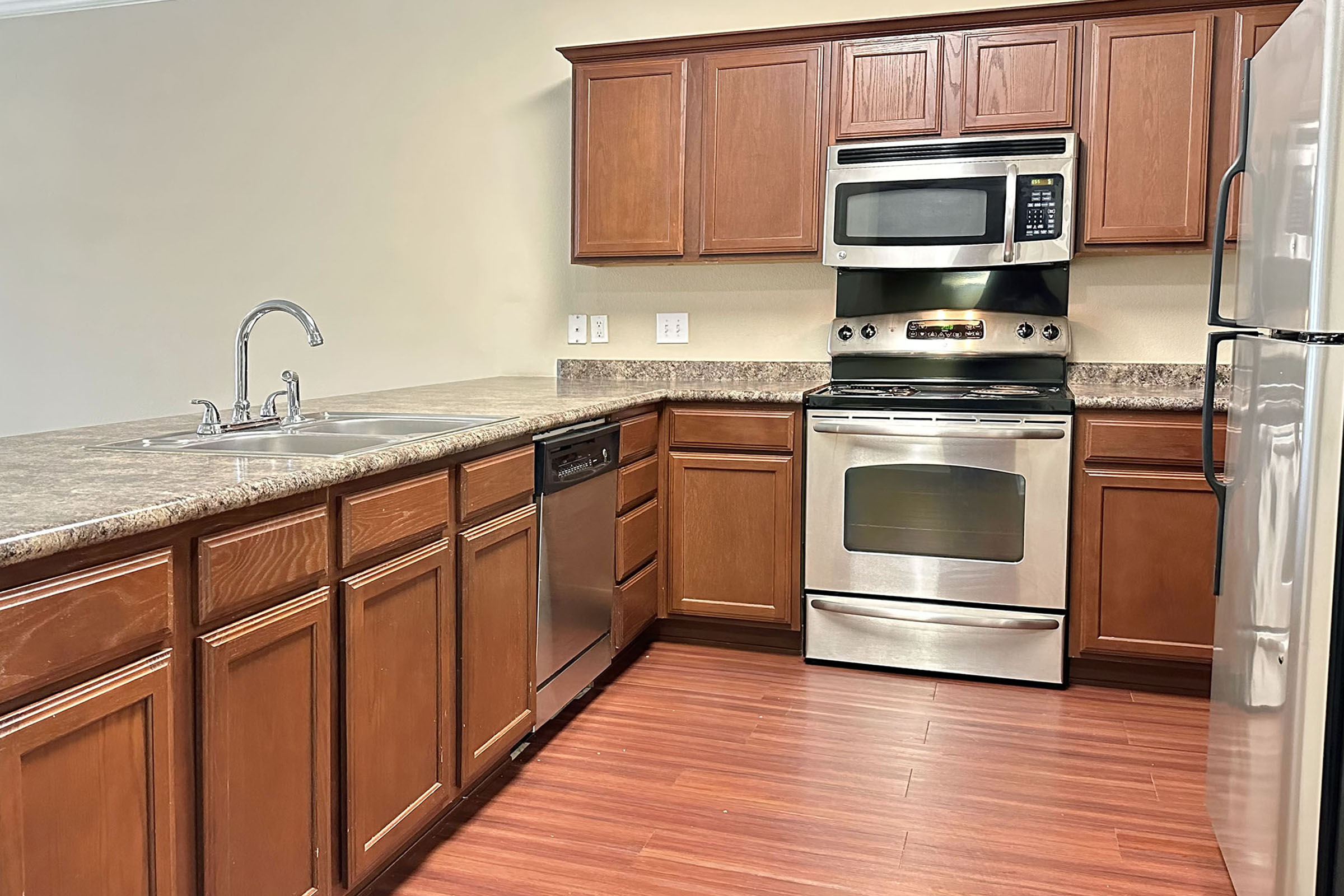 a kitchen with stainless steel appliances and wooden cabinets