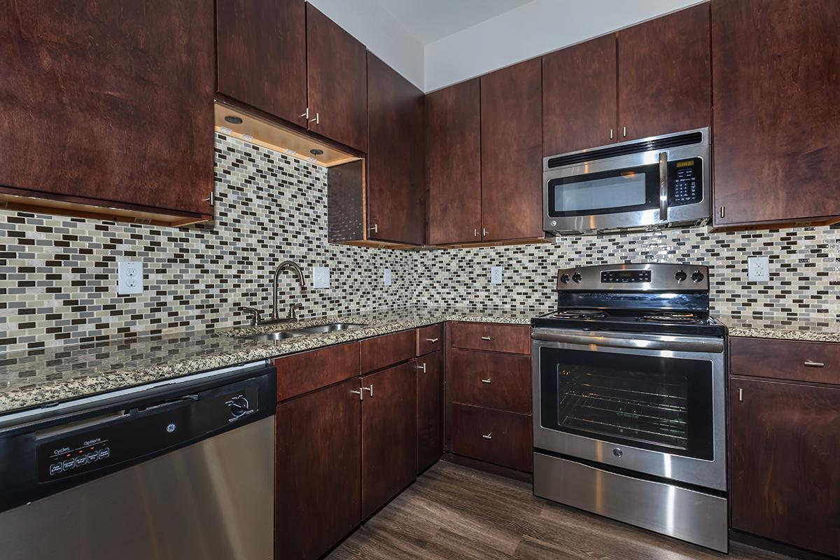 a modern kitchen with stainless steel appliances and wooden cabinets